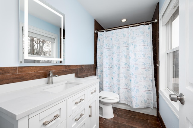 full bathroom featuring shower / tub combo, vanity, toilet, wood tiled floor, and tile walls