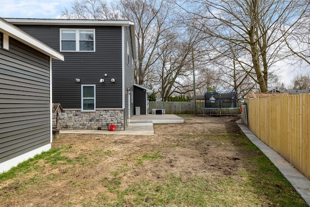view of yard featuring a patio area, a fenced backyard, and a trampoline