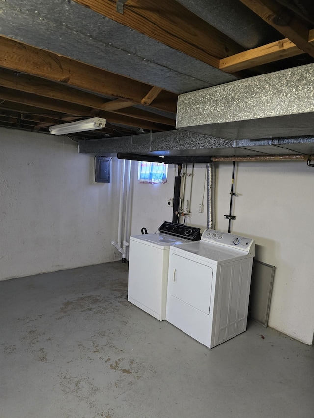 basement with electric panel and washer and clothes dryer
