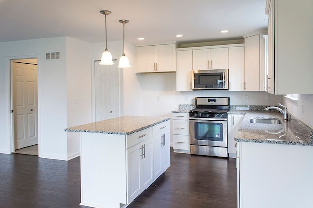 499 Cannonade Loop, Howell, MI 48843 - kitchen featuring visible vents, light stone counters, a sink, stainless steel appliances, and dark wood-style floors