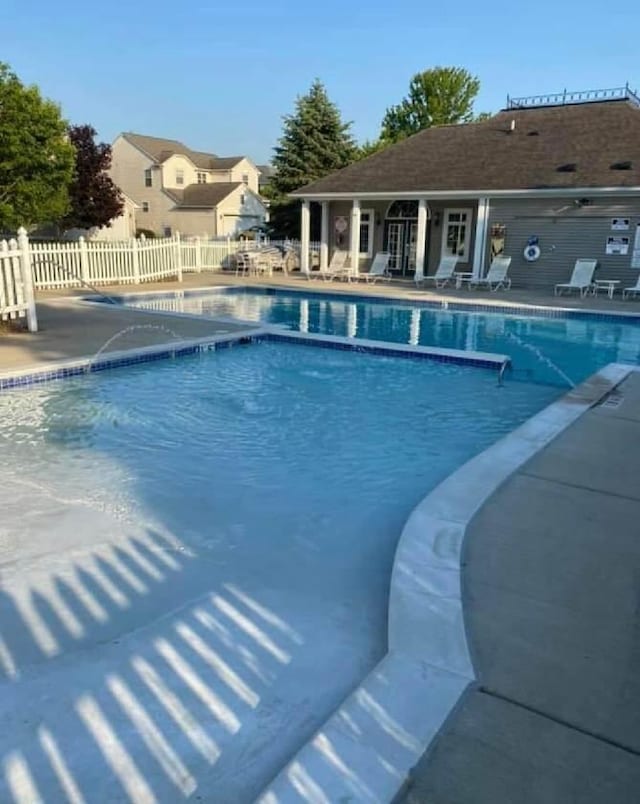 community pool featuring a patio area and fence