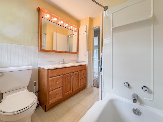 full bathroom featuring vanity, tile patterned floors, wainscoting, and toilet