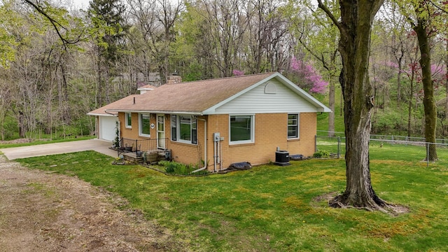 view of front of house with fence, a front yard, a chimney, brick siding, and driveway