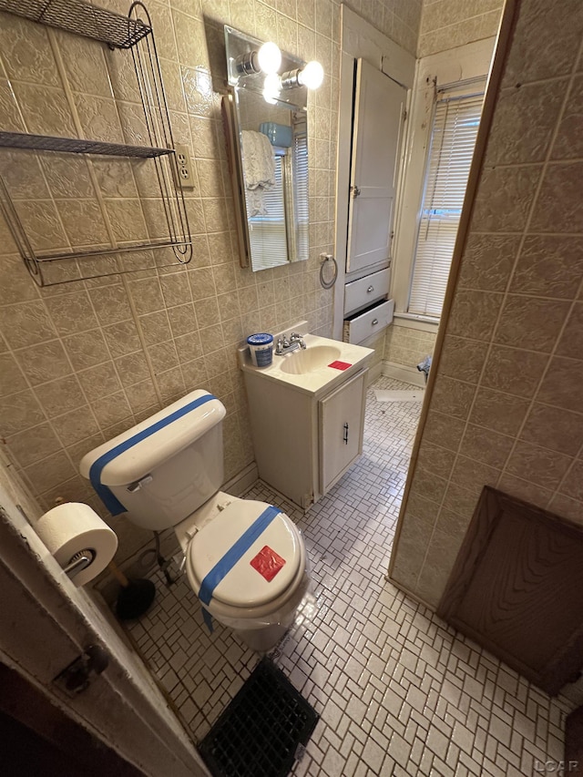 140 Moore St, Jackson, MI 49203 - bathroom featuring vanity, tile walls, and toilet