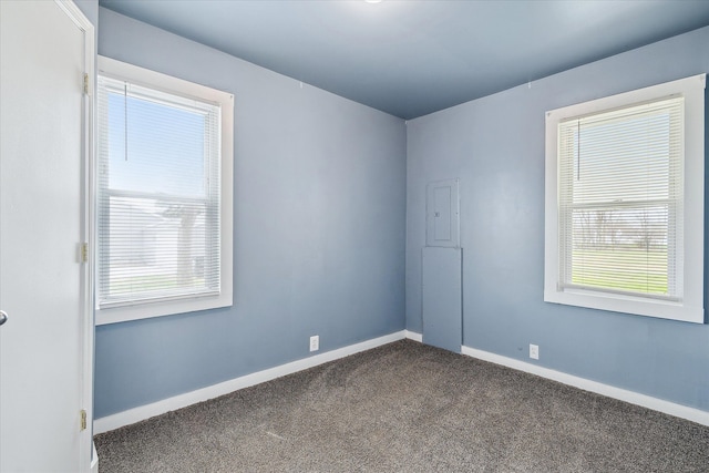 unfurnished room featuring dark colored carpet and baseboards
