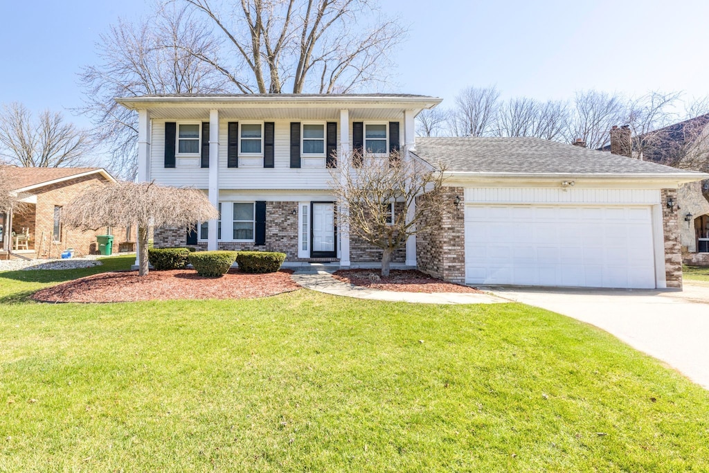 view of front of home featuring a garage, brick siding, driveway, and a front lawn