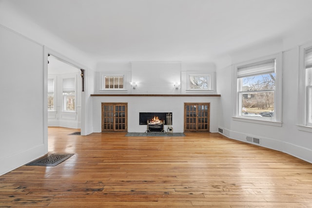 250 Alger St, Detroit, MI 48202 - unfurnished living room featuring a fireplace with flush hearth, wood-type flooring, and visible vents