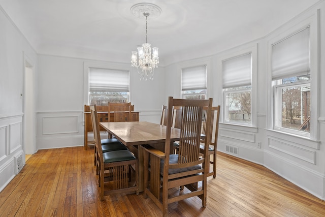 250 Alger St, Detroit, MI 48202 - dining space featuring a decorative wall, visible vents, light wood-style flooring, and a chandelier