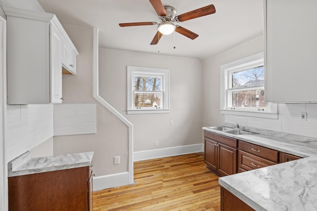 250 Alger St, Detroit, MI 48202 - kitchen featuring baseboards, a sink, a ceiling fan, light wood finished floors, and decorative backsplash