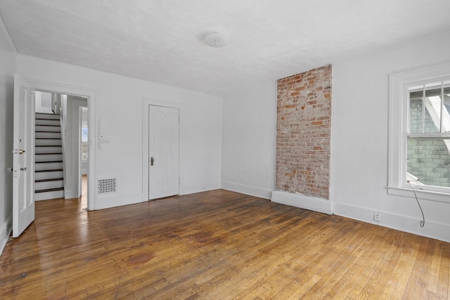 250 Alger St, Detroit, MI 48202 - unfurnished room featuring visible vents, baseboards, hardwood / wood-style flooring, and stairs