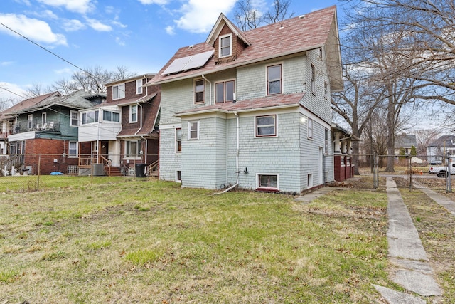 250 Alger St, Detroit, MI 48202 - rear view of property with a residential view, fence, solar panels, and a lawn