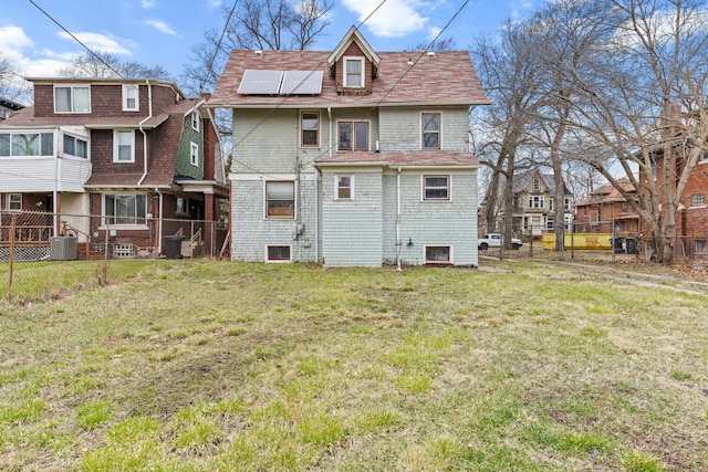 250 Alger St, Detroit, MI 48202 - back of house featuring roof mounted solar panels, a lawn, fence, cooling unit, and a residential view
