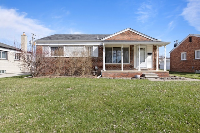 ranch-style home with covered porch, a front yard, and brick siding