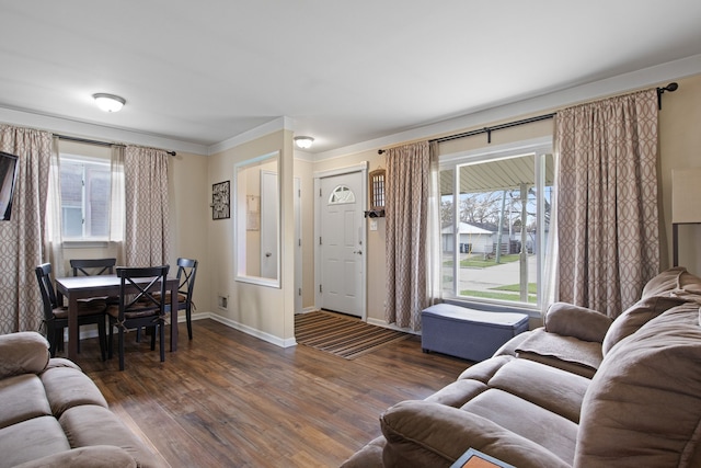 living room featuring plenty of natural light, baseboards, crown molding, and wood finished floors