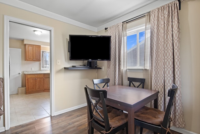 dining area featuring light wood-style flooring and baseboards
