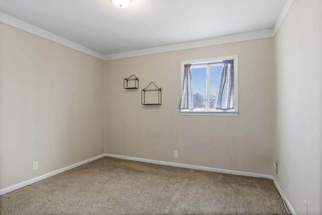 carpeted spare room with ornamental molding and baseboards