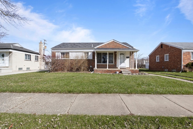 bungalow-style house with brick siding, a front lawn, and covered porch