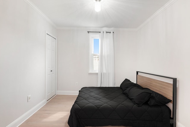 bedroom featuring crown molding, light wood finished floors, and baseboards