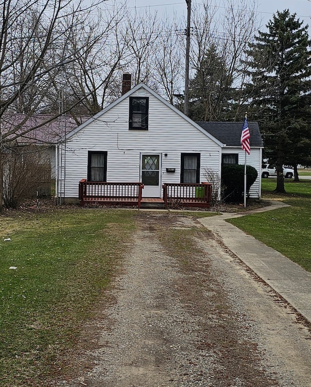 view of front of home featuring a front lawn, a deck, and a chimney