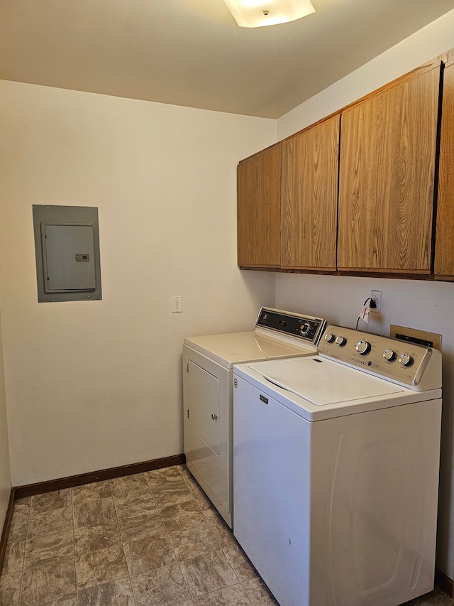 clothes washing area featuring electric panel, washing machine and dryer, baseboards, and cabinet space