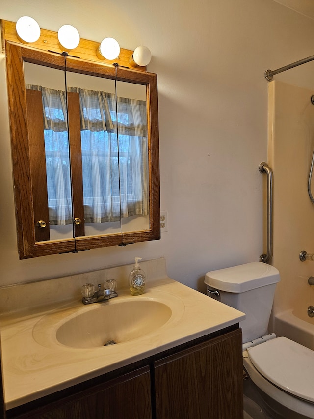 bathroom with toilet, vanity, and  shower combination