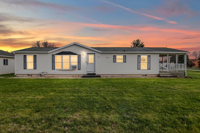 back of house at dusk featuring crawl space and a yard