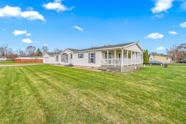 rear view of property with crawl space, a garage, fence, a lawn, and covered porch