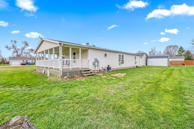 rear view of house featuring a yard and a porch