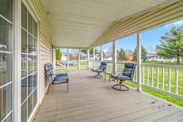 wooden terrace with a residential view and a lawn