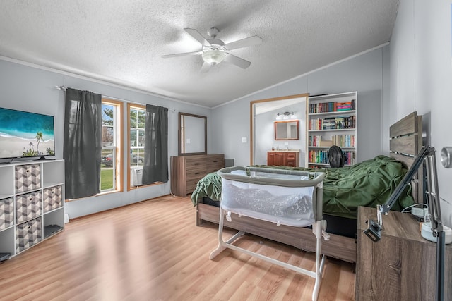 bedroom with lofted ceiling, ornamental molding, a textured ceiling, ceiling fan, and wood finished floors
