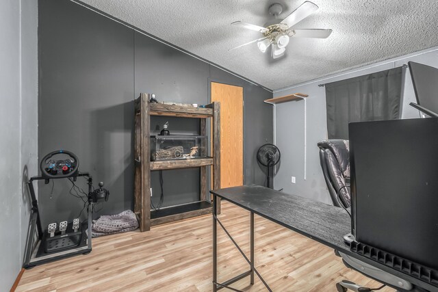 office area featuring ceiling fan, vaulted ceiling, wood finished floors, and a textured ceiling