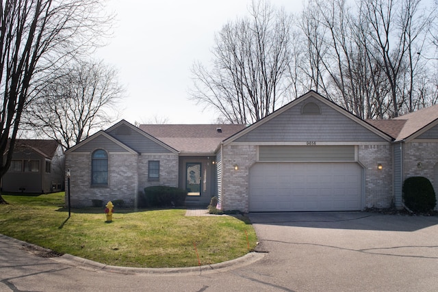 ranch-style home with a front lawn, brick siding, driveway, and a garage