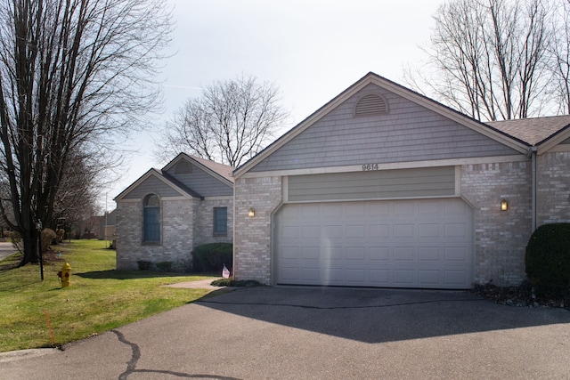 ranch-style home with concrete driveway, a front yard, brick siding, and an attached garage