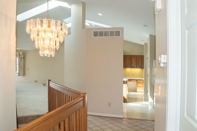 corridor with a notable chandelier, light tile patterned floors, visible vents, vaulted ceiling, and an upstairs landing
