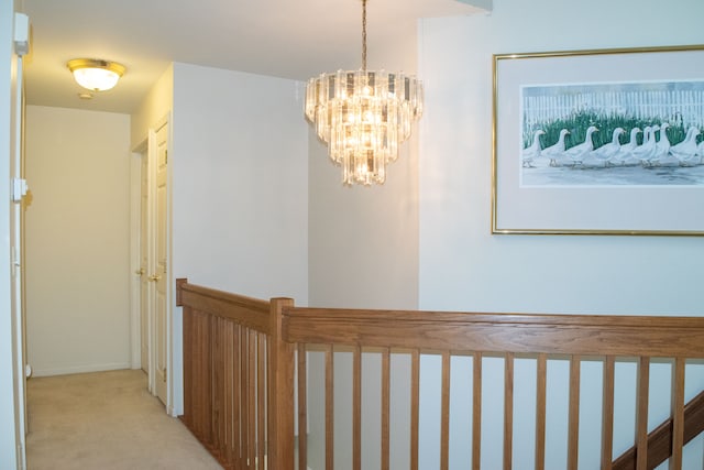 hallway featuring an inviting chandelier and carpet floors