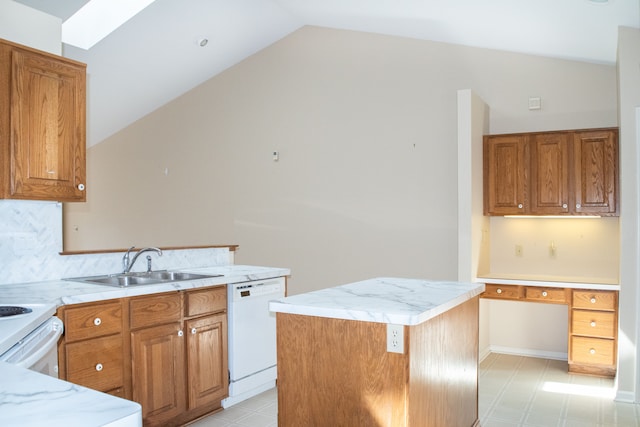 kitchen featuring lofted ceiling with skylight, a sink, light floors, dishwasher, and decorative backsplash
