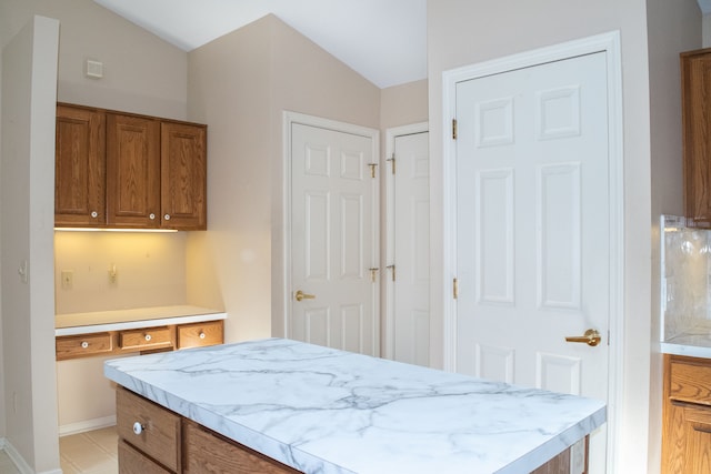 interior space with baseboards, a center island, and brown cabinets