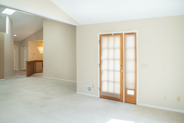 unfurnished room featuring light colored carpet, visible vents, and vaulted ceiling with skylight
