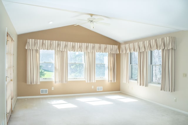 carpeted spare room featuring baseboards, lofted ceiling, visible vents, and a ceiling fan