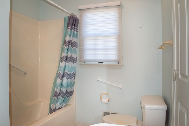 bathroom featuring shower / tub combo with curtain and toilet