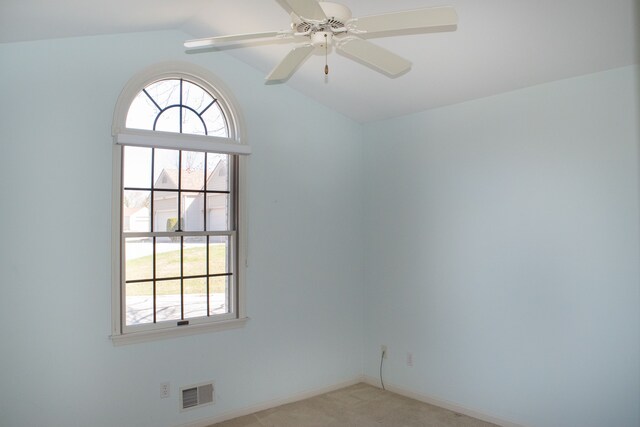 empty room with light carpet, lofted ceiling, plenty of natural light, and visible vents