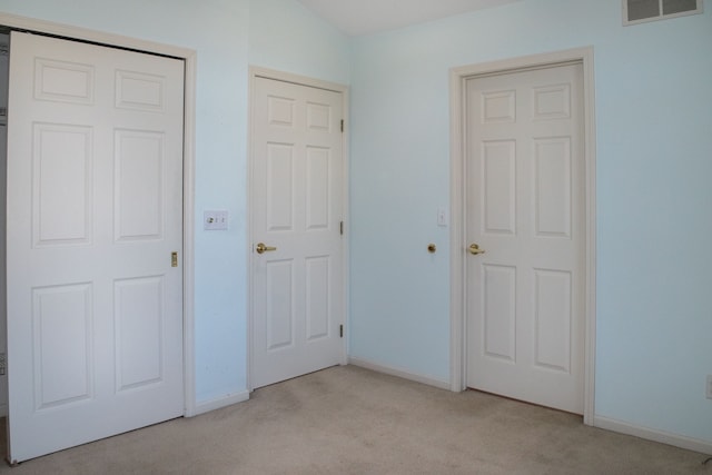 unfurnished bedroom featuring light colored carpet, baseboards, and visible vents