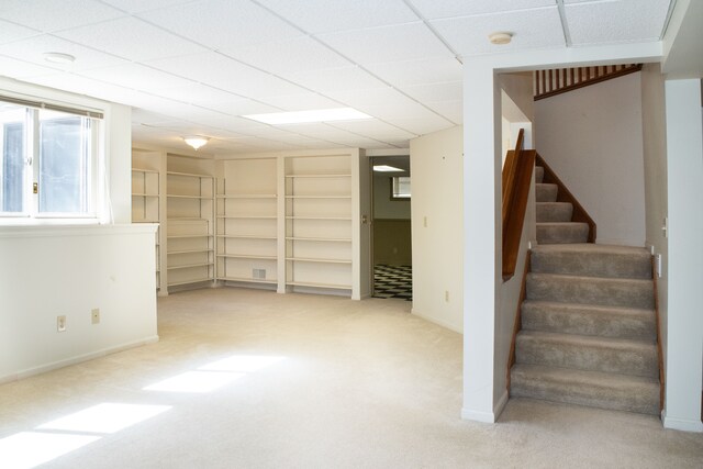basement featuring baseboards, stairway, built in features, and carpet floors
