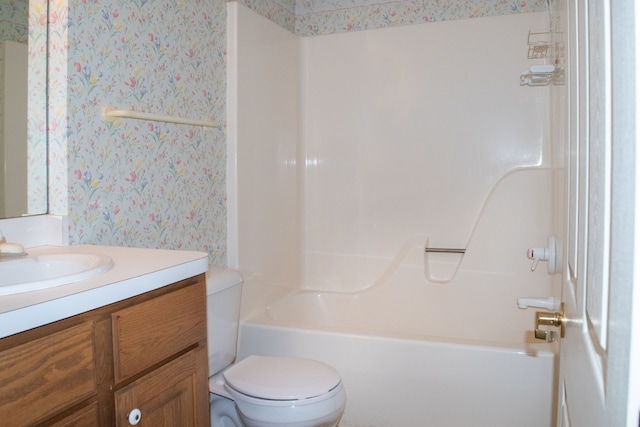 bathroom with toilet, vanity, wallpapered walls, and shower / washtub combination