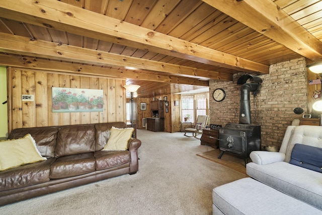 living room with wooden ceiling, a wood stove, wooden walls, beam ceiling, and carpet floors