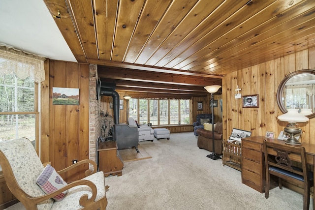 interior space with wood walls, a wood stove, wooden ceiling, and carpet flooring