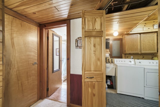 clothes washing area featuring independent washer and dryer, wood ceiling, wood walls, and cabinet space