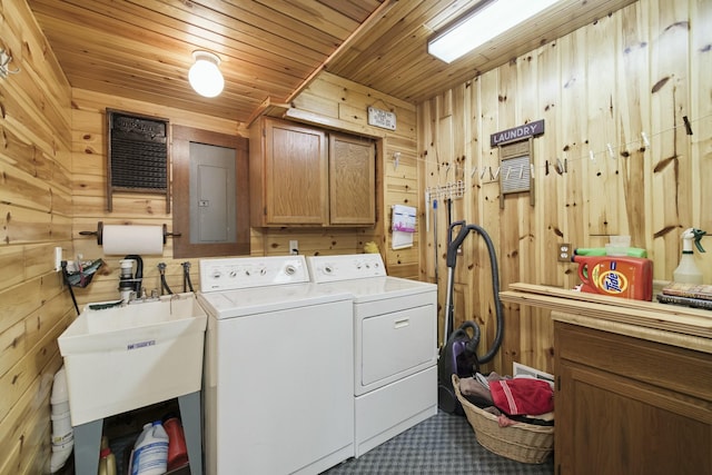 washroom featuring wood walls, wood ceiling, washing machine and clothes dryer, and cabinet space