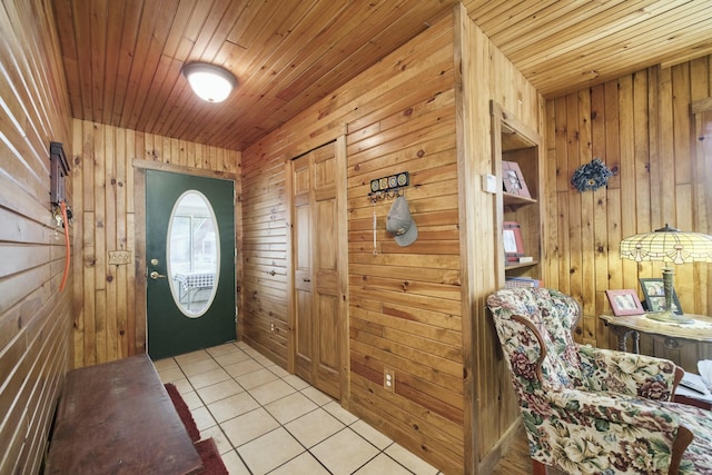 foyer entrance featuring wood walls, light tile patterned floors, and wood ceiling