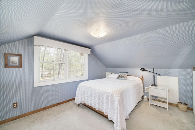 bedroom featuring wallpapered walls, baseboards, vaulted ceiling, and carpet floors
